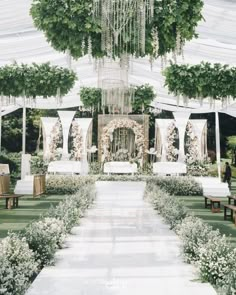 an outdoor wedding setup with white linens and greenery