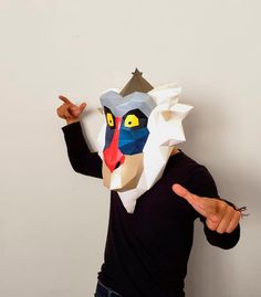 a man wearing a paper mask and pointing to the side with his hand in front of him