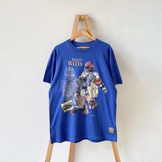 a blue t - shirt hanging on a wooden hanger