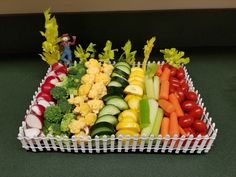 a tray filled with lots of different types of fruits and vegetables on top of a table