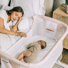 a woman sleeping next to a baby in a crib