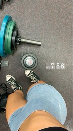 a person standing next to a pair of dumbbells with their feet on the ground