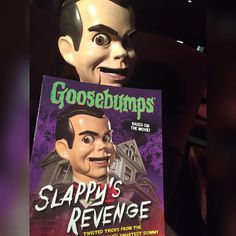 a creepy doll holding a book about slappy's revenge and goosebumps