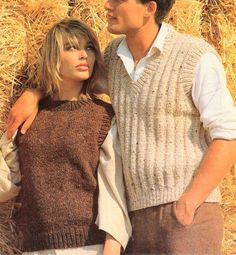 two people standing next to each other in front of hay