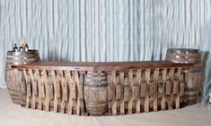 two wooden barrels sitting next to each other in front of a curtained wall with blue drapes