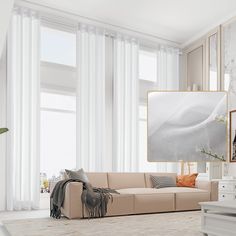 a living room filled with furniture and large windows covered in white drapes, next to a beige couch