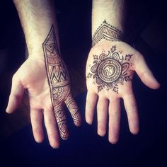 two hands with henna tattoos on them