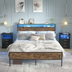 a bedroom with a bed, nightstands and pictures on the wall above it in blue tones