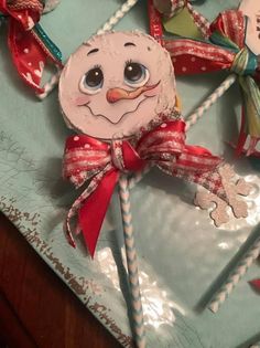 a snowman ornament on a plate with candy canes