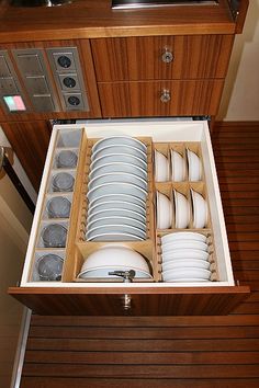 an open drawer with dishes in it