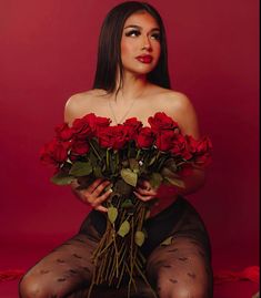 a woman in fishnet stockings holding roses with her hands on her hips and looking at the camera