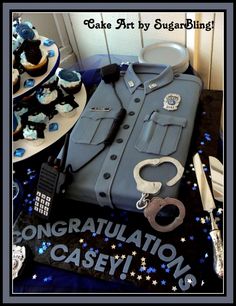 a cake made to look like a police uniform with handcuffs and keys on the table