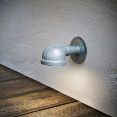 a door handle on the side of a white building with wood flooring and walls