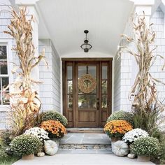 two large pumpkins are sitting in front of a door with flowers on the steps