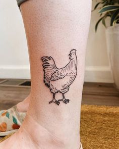 a small chicken tattoo on the ankle