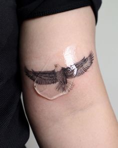 an eagle tattoo on the side of a woman's right leg, with clear acrylic