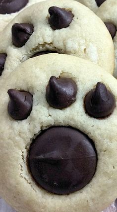 three cookies with chocolate chips in the shape of a dog's face