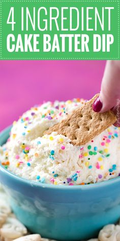 a hand dipping a cracker into a bowl of cake batter dip