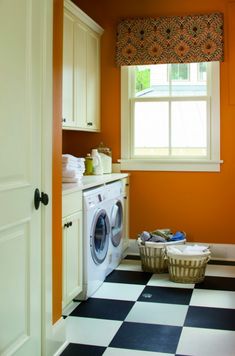 an orange and black checkered floor in a laundry room with washer and dryer