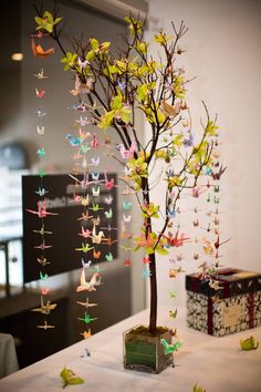 a small tree is decorated with origami birds