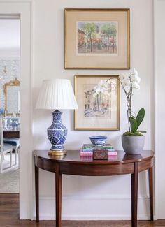 a table with two vases and a lamp on it in front of a doorway