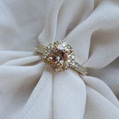 an engagement ring sitting on top of a white cloth