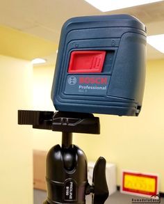 a tripod with a red light on top of it in an office cubicle