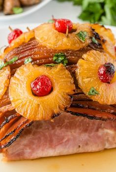 baked ham with brown sugar glaze and pineapples on top is served on a white plate