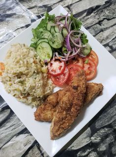 a white plate topped with chicken, rice and veggies