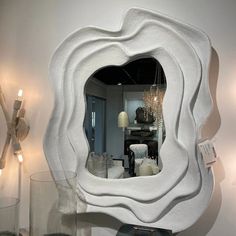 a mirror that is sitting on top of a table next to vases and candles