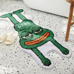 a bathroom rug with a green creature on the floor