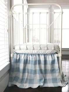 a bed with a blue and white checkered bedspread next to a window