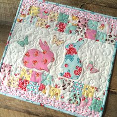 a close up of a patchwork quilt on a wooden floor with an animal theme