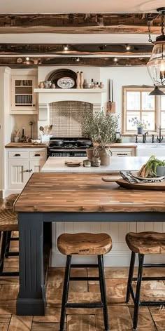 a kitchen with an island and stools next to the counter top in front of it