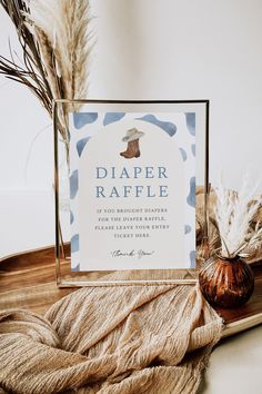 there is a sign that says diaper raffle next to some dried plants on a tray