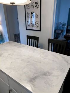 a kitchen counter top with chairs in the background