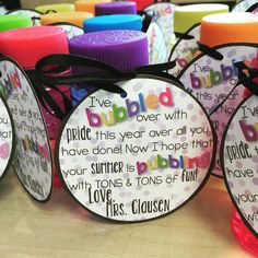 several different colored bottle caps with sayings on them and ribbons tied around the top