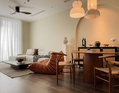 a living room filled with furniture next to a window covered in white curtains and lights