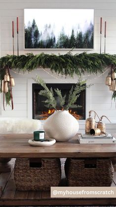 a living room decorated for christmas with greenery on the mantel