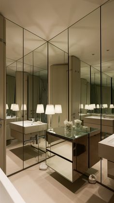 a bathroom with mirrors, sinks and lamps in it