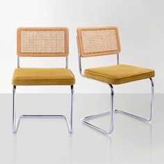 two chairs with green upholstered seat covers on them, one is made out of wood and the other is metal