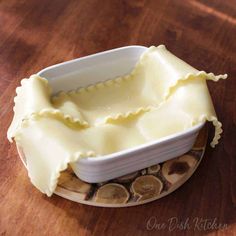 a dish that has some kind of food inside of it on a wooden table top