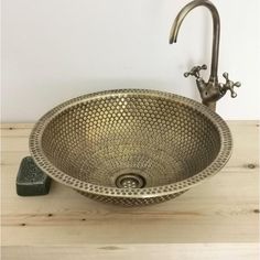 a bathroom sink sitting on top of a wooden counter next to a faucet