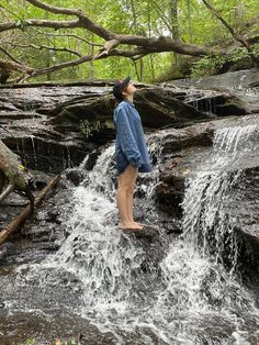 a woman standing on top of a waterfall