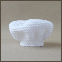 a crocheted white object sitting on top of a table