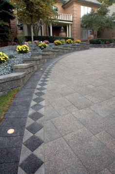 a driveway with steps and landscaping around it