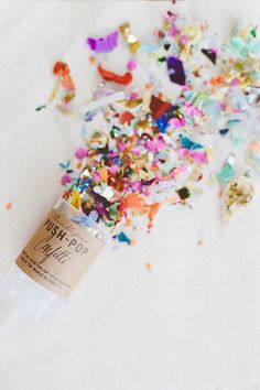 a bottle filled with confetti and sprinkles on top of it