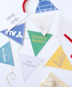 some pennants are hanging on a white surface with red string and twine around them