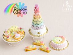 miniature cakes and pastries are on display in the shape of a rainbow cake tower