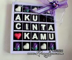 a box filled with chocolates that spell out the word kau cinta komu